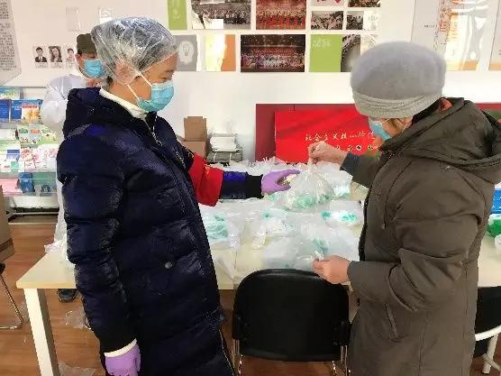 為樓棟分發(fā)口罩，并為包裝袋消毒